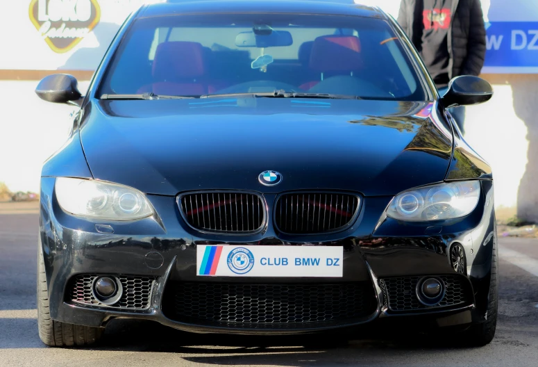 a bmw car parked on a street with a man standing next to it