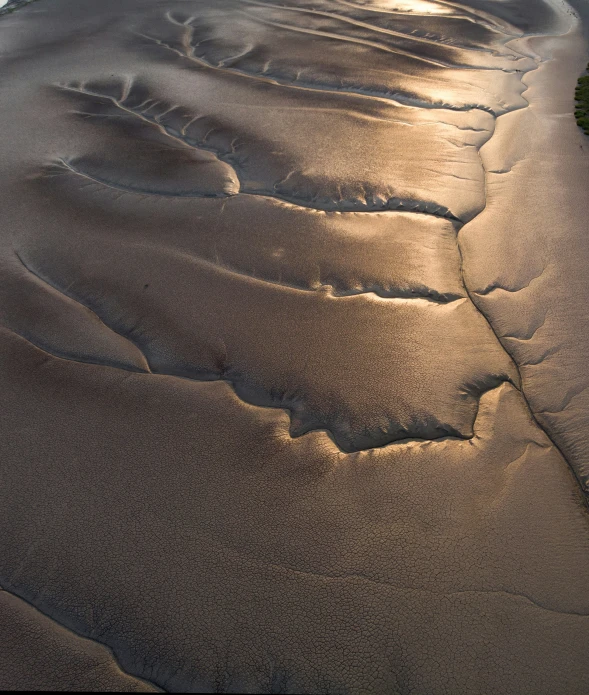 a sunset view from the air shows the wavy and sandy sand