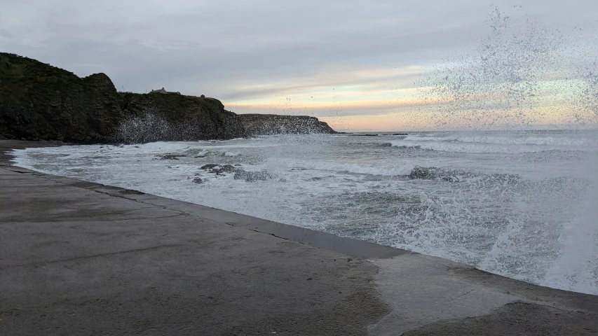 the water sprays on a beach and shoreline