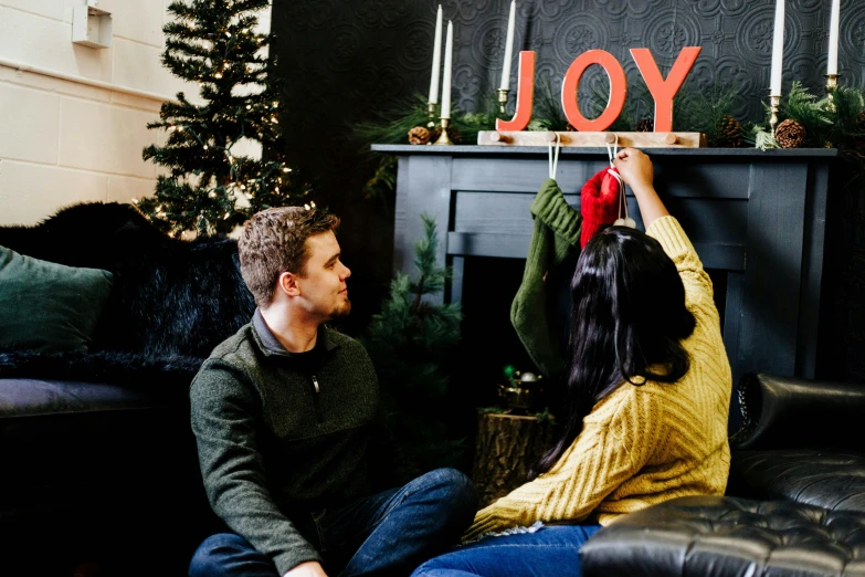 a man and woman sitting on a couch looking at each other in the living room