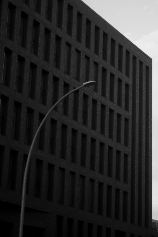 black and white pograph of a pole in front of a building