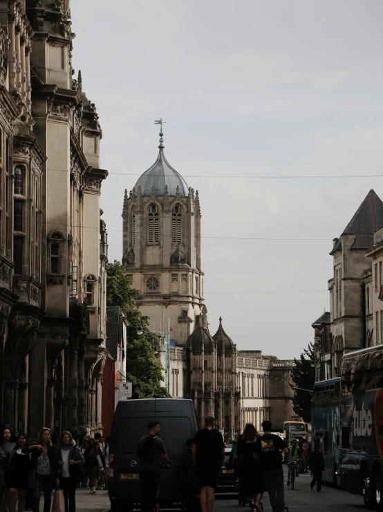 people walking near old buildings with a big cathedral in the background