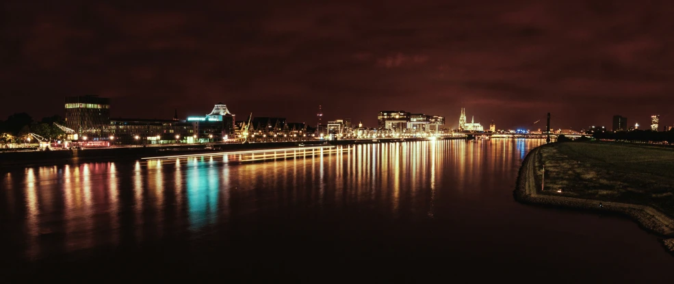 a view of the city lights at night from across the river