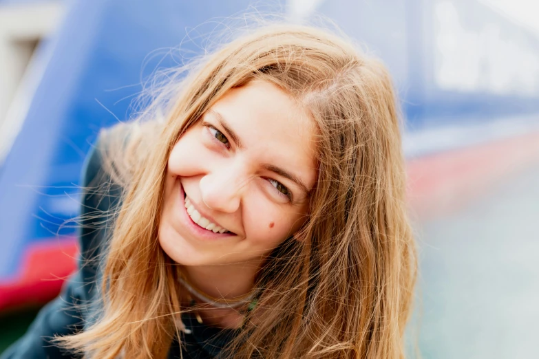 a young lady smiles outside in a public area