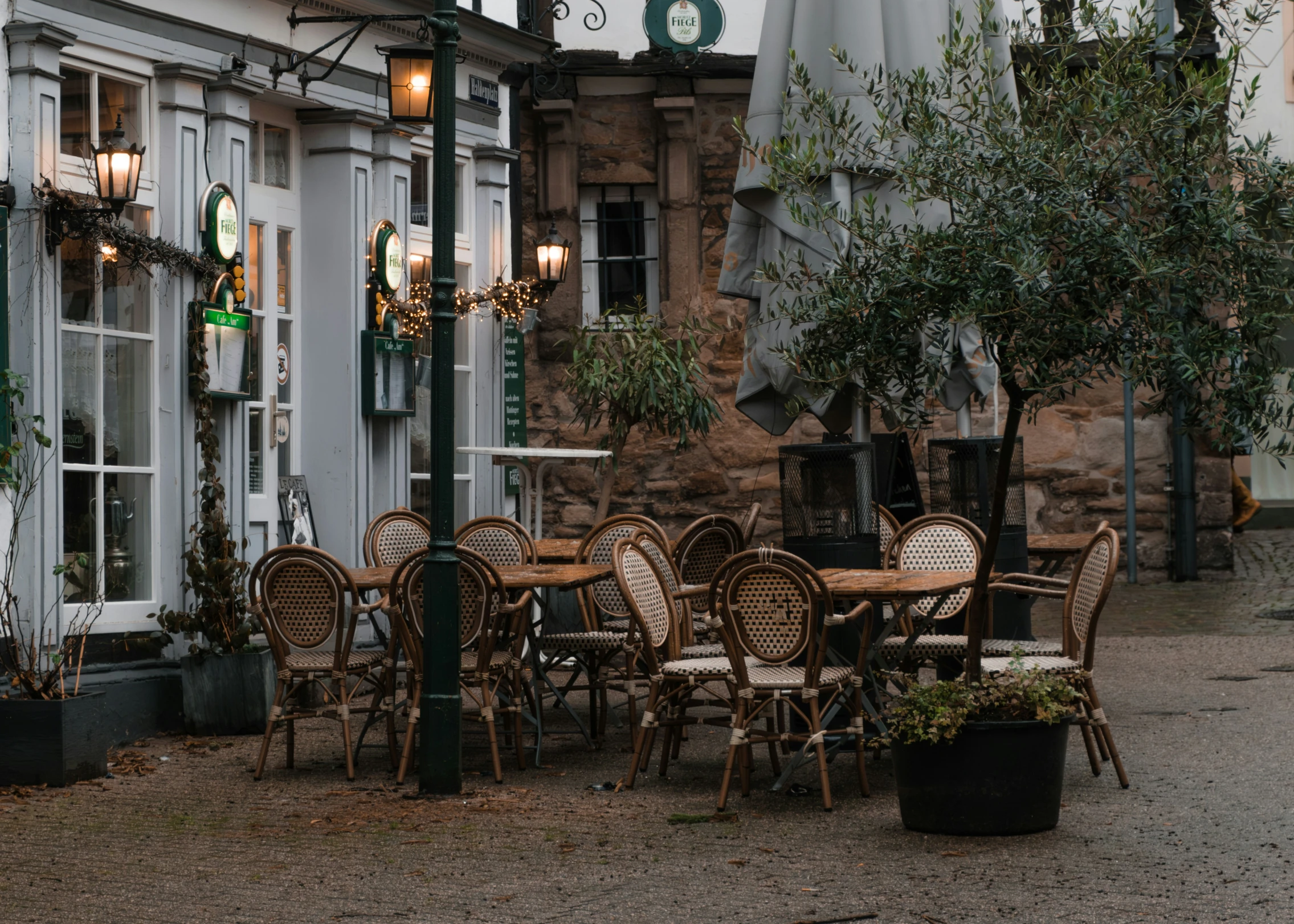 tables, chairs and umbrellas are arranged outside a building