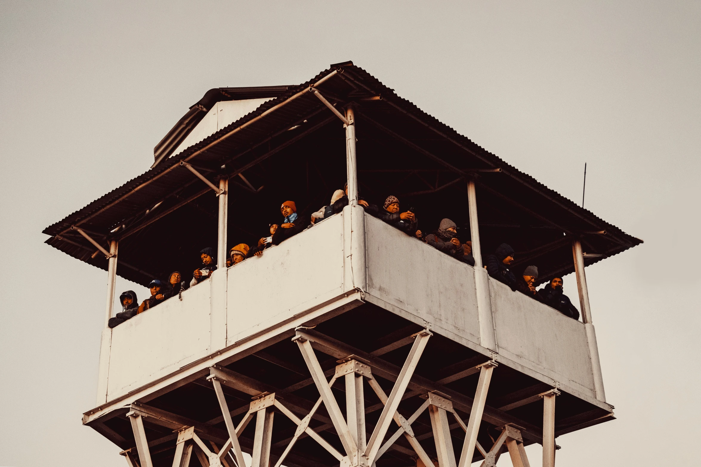 people standing on the balcony and under an observation tower