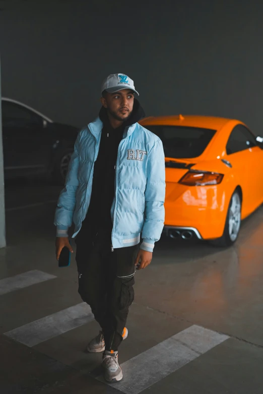 a man stands near a sports car while wearing a jacket