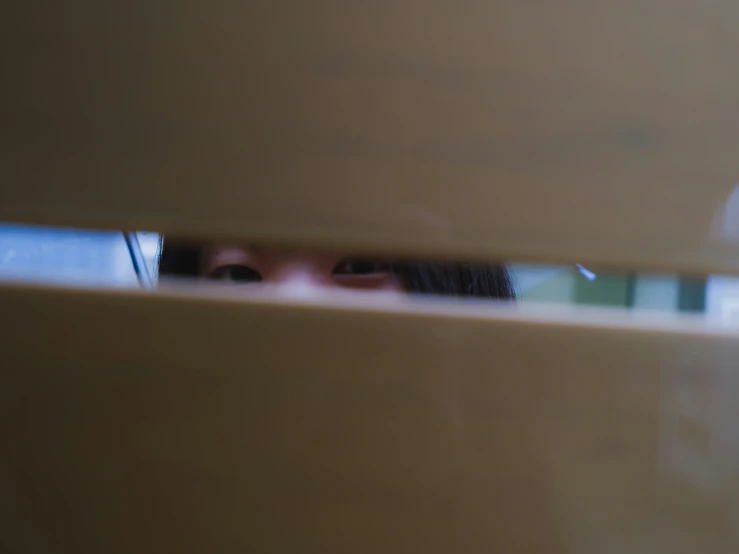 a close up of a girl looking through a hole