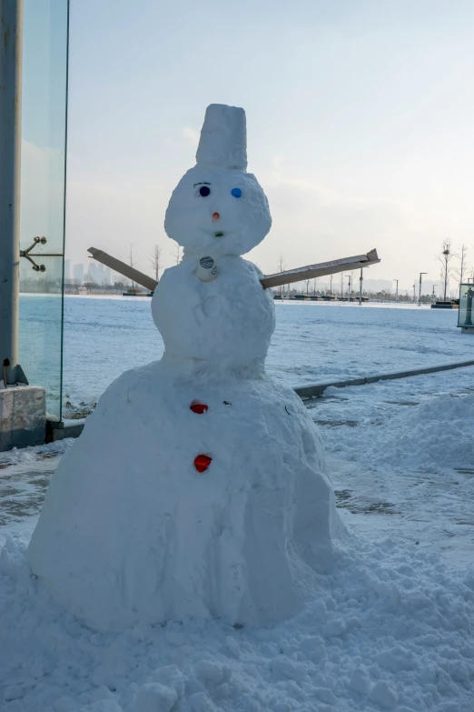 a snowman is next to the sign in front of a building