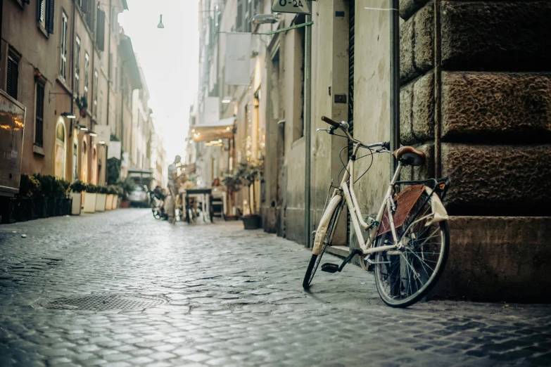 a bike is parked on a narrow cobblestone street