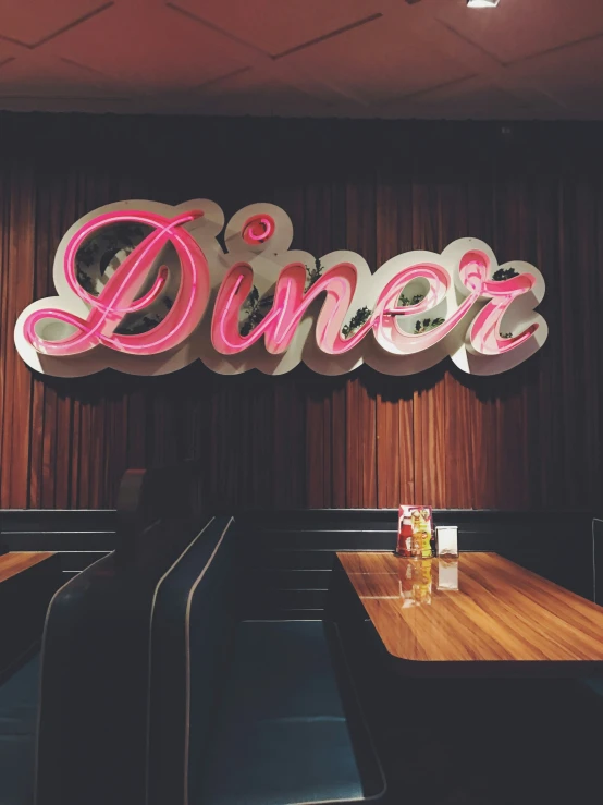 a wooden restaurant with chairs and large neon sign