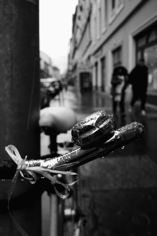 black and white image of some bread wrapped in rope on sidewalk