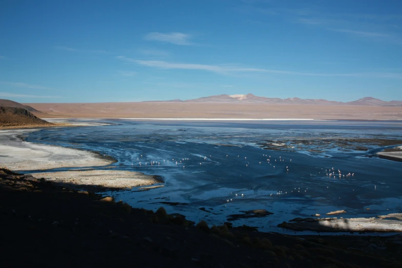 a large body of water sitting on top of a rocky hillside