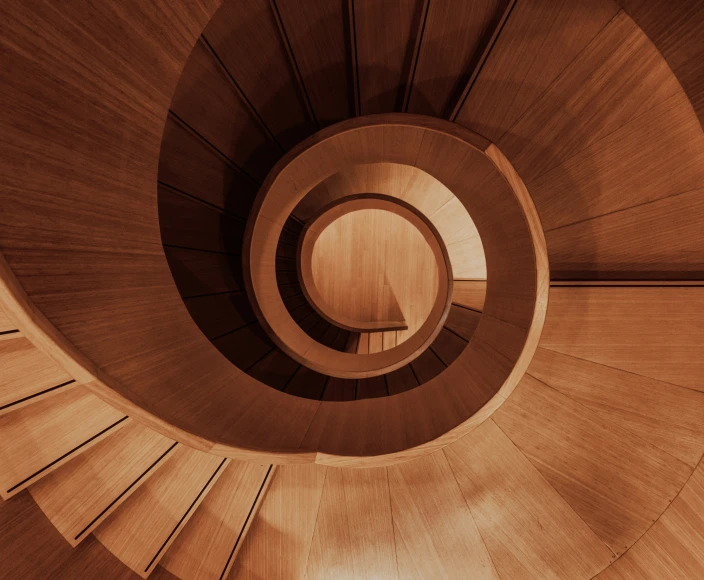 an overhead view of an intricately constructed wooden spiral staircase