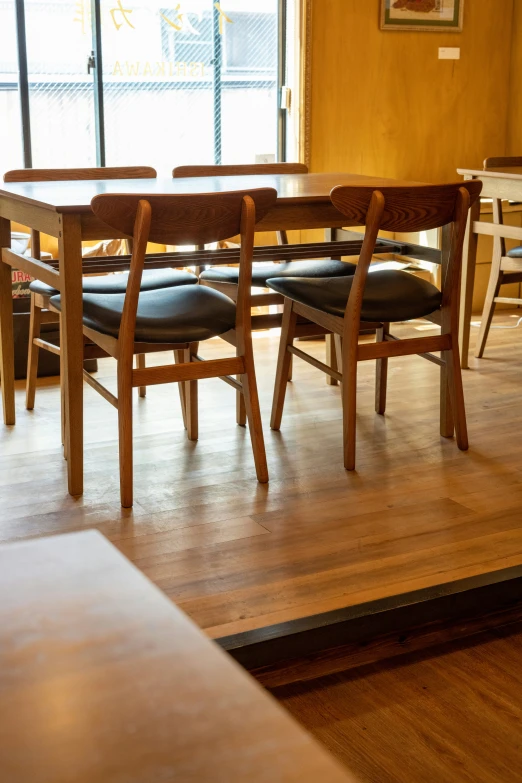 an empty table with several chairs is seen