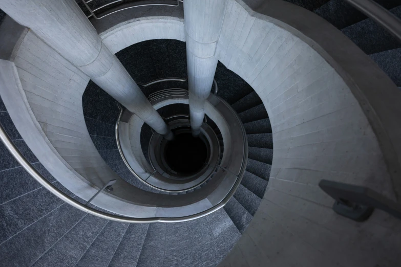 a spiral staircase in concrete with stone floor