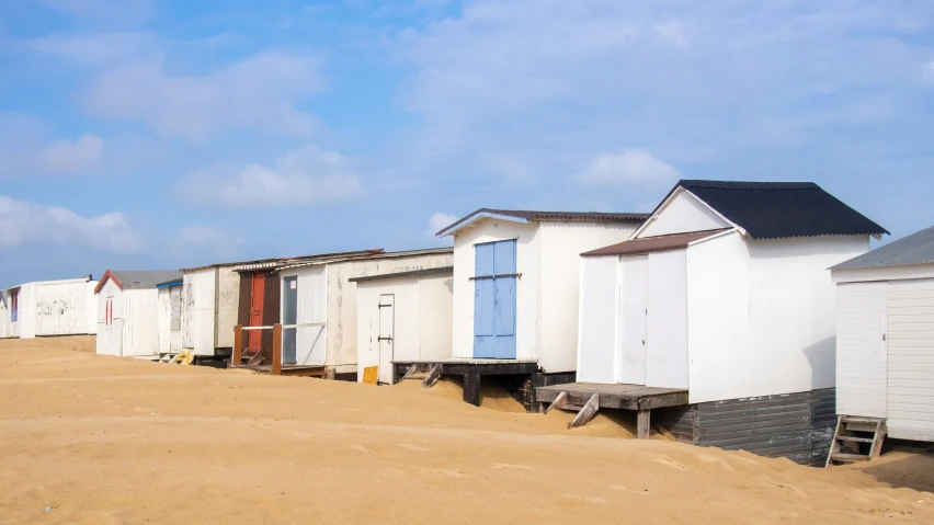 a row of beach huts with chairs by them