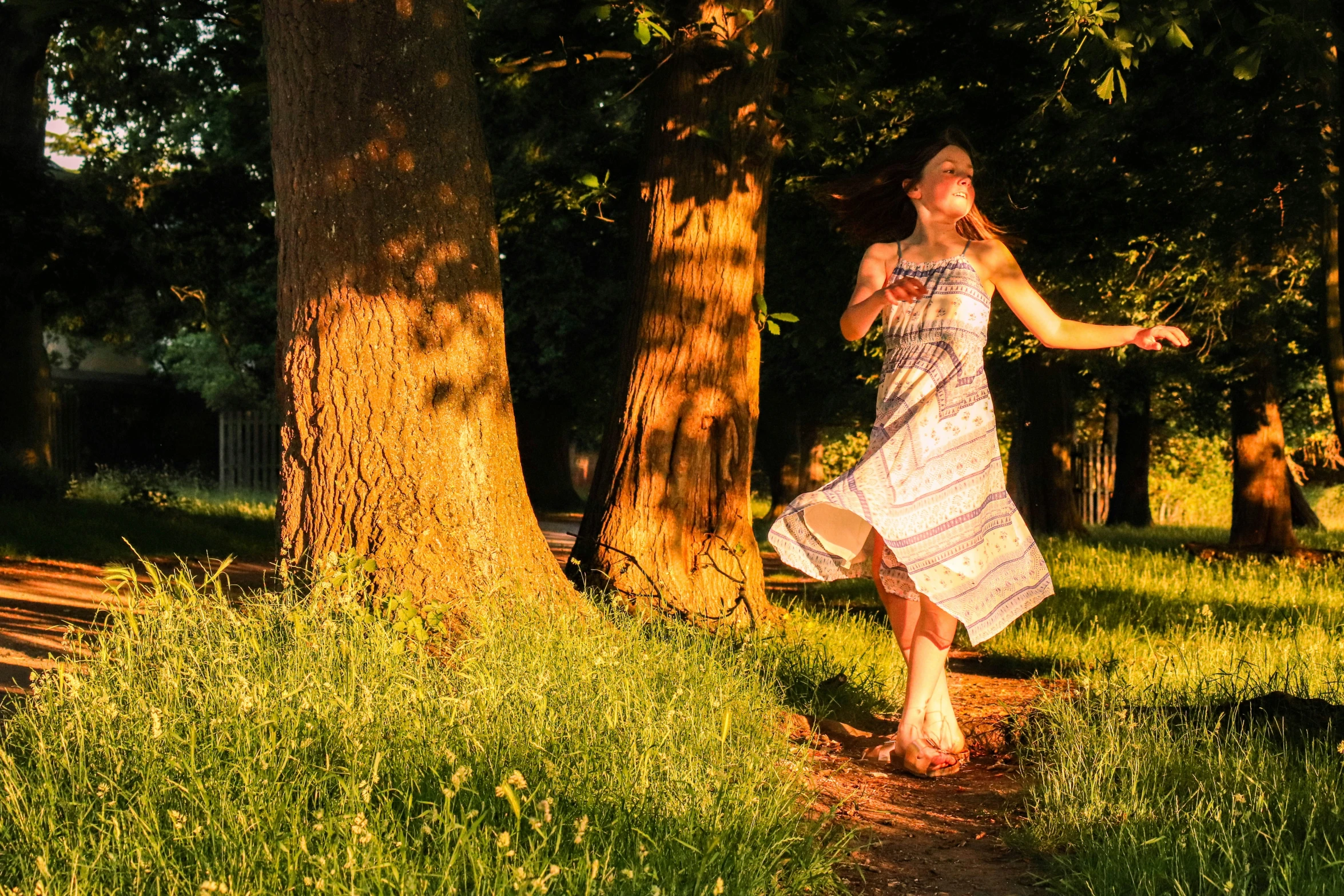 a young woman wearing a patterned dress playing with a frisbee