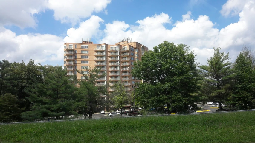 buildings on the edge of a park with cars parked by