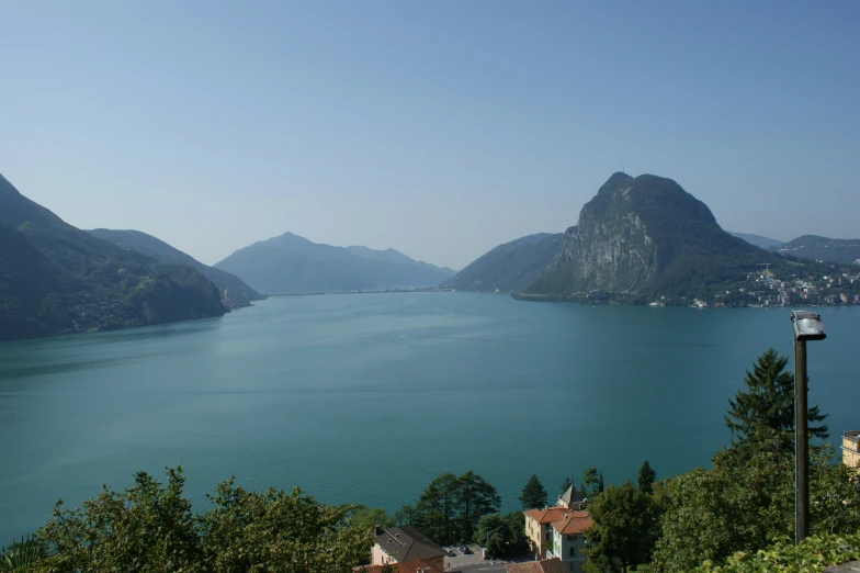 a lake and mountains near a road with the sky