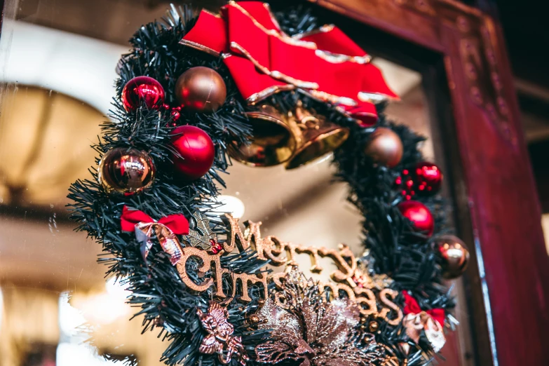 a wreath hanging on a red wooden door