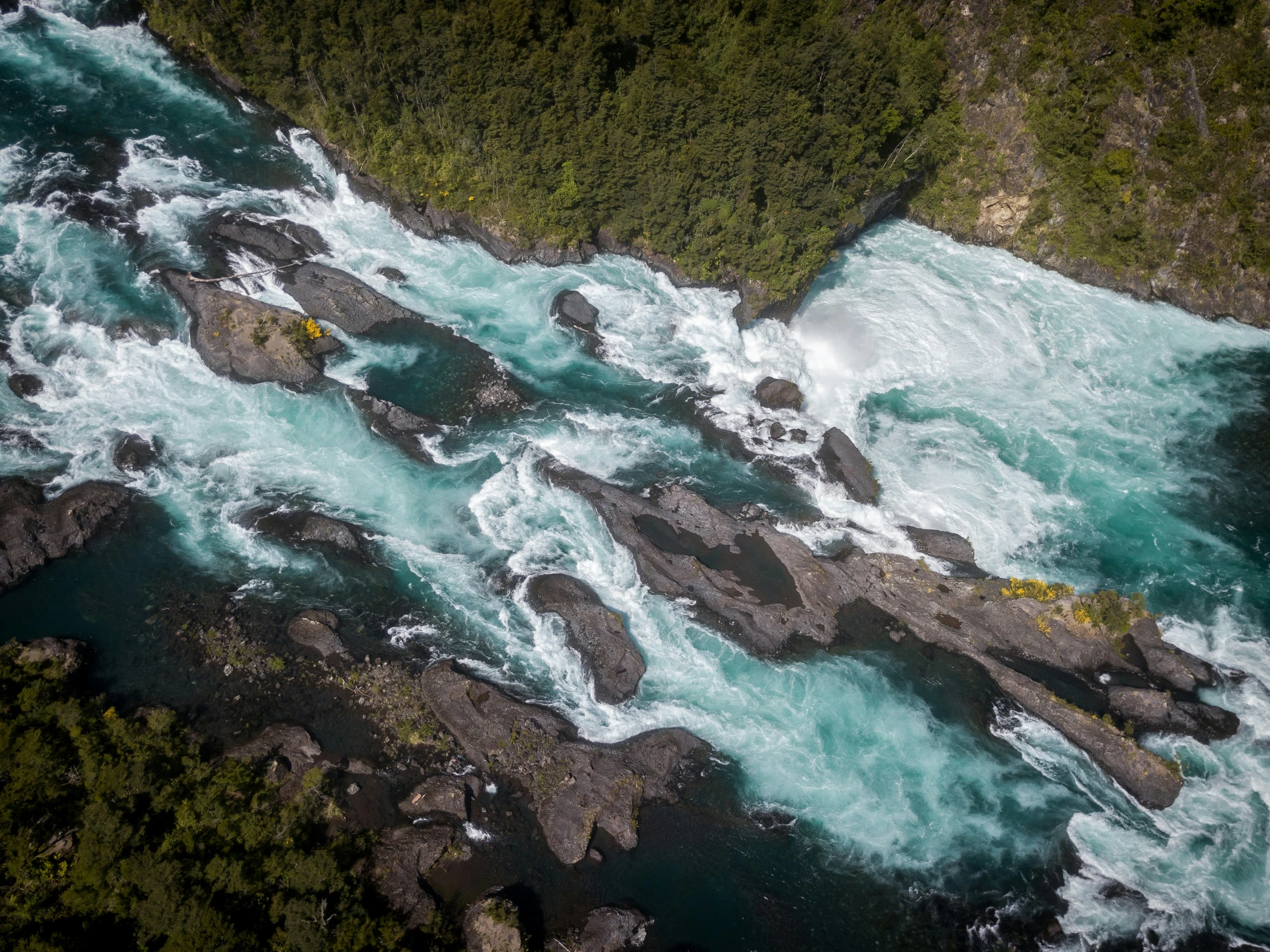 water is blue and green near some rocks