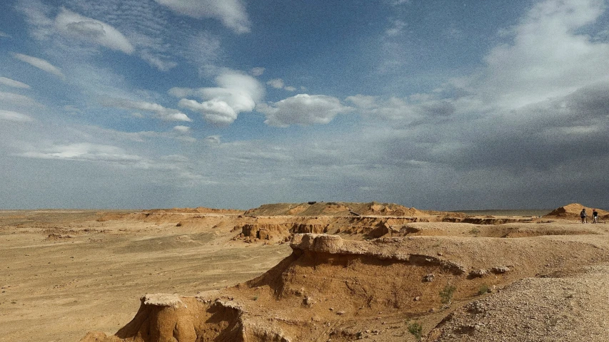 an open desert with some sand and rocks