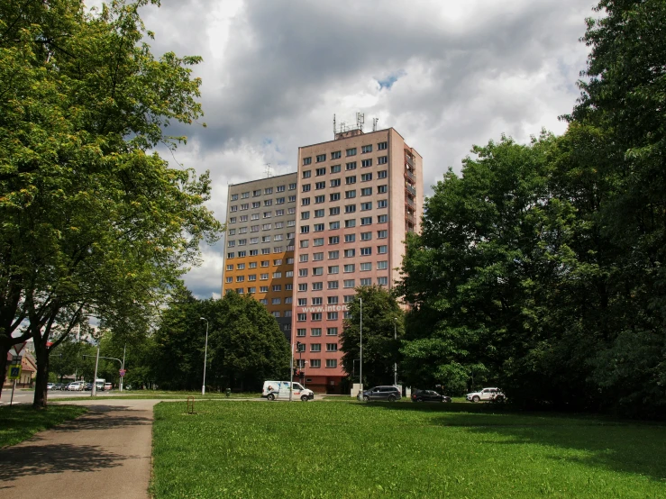 an apartment building with parking and green grass