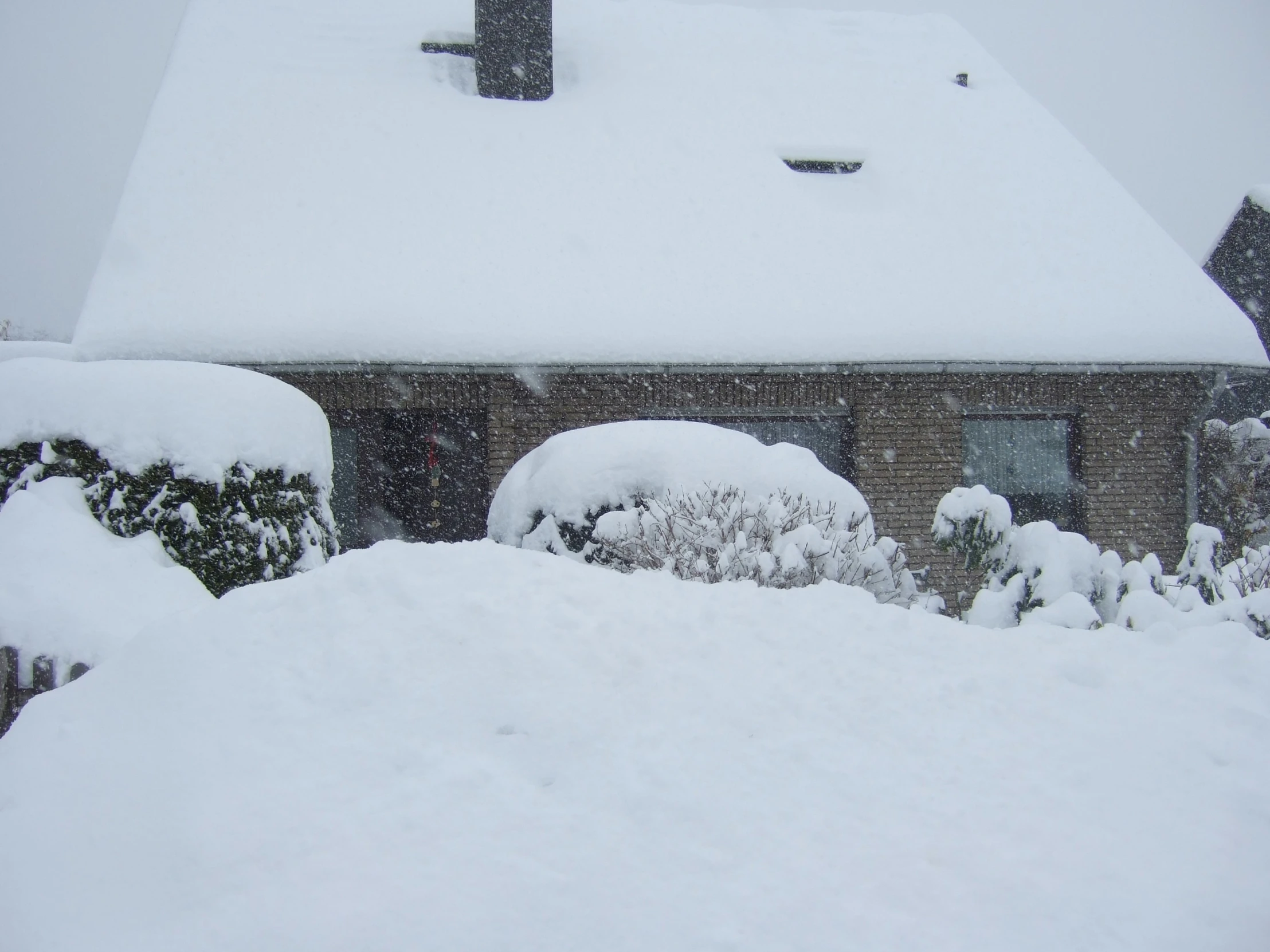 this is a house covered in snow on a cold day