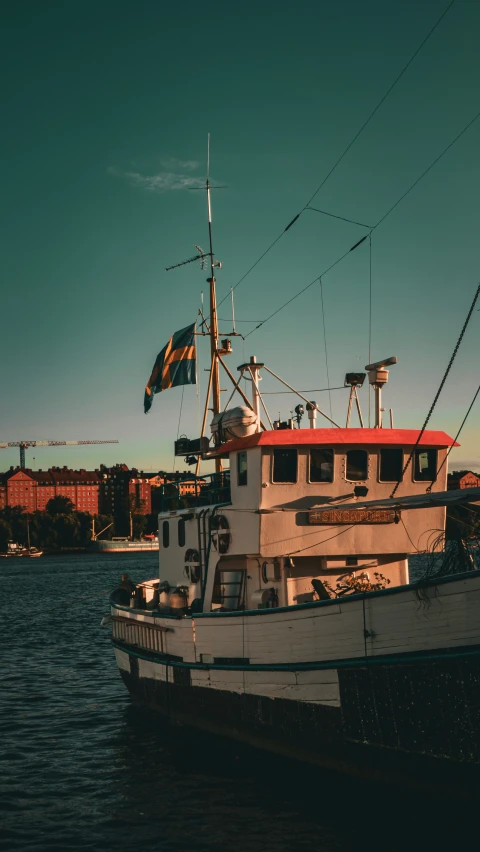 the boat is docked on the water, next to buildings