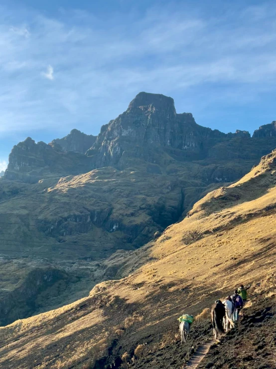 four people walking up a mountain side