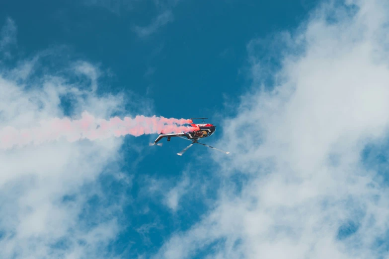 a helicopter flying in the sky with smoke pouring out of it