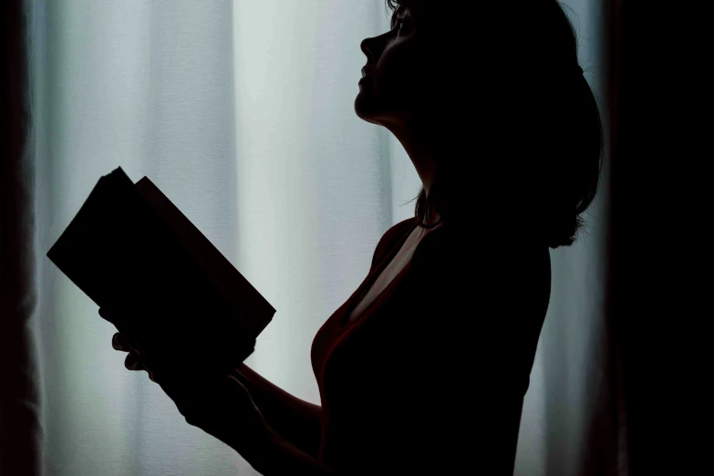 a woman with short hair is holding a book