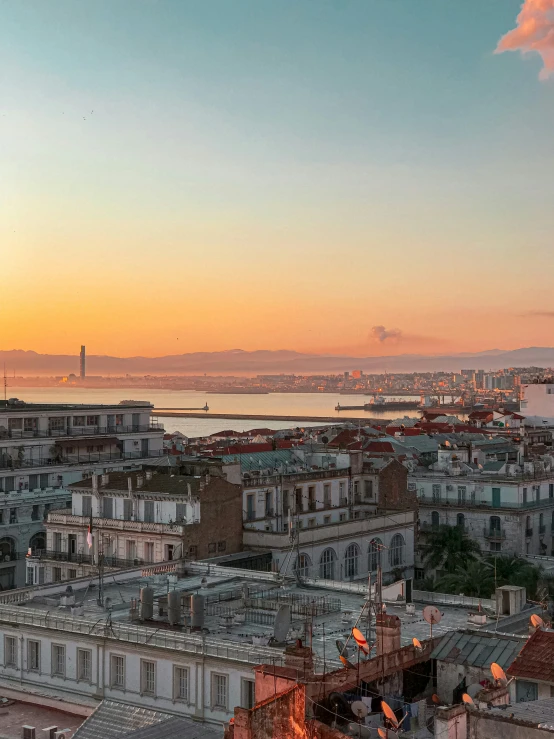 a bright sunset over some buildings in a town