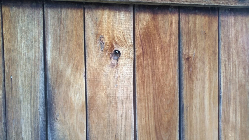 the side of a wooden house is made up of planks and nails