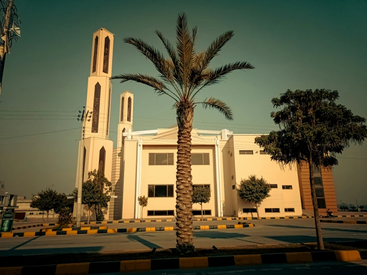 a building with a tower and a tall palm tree