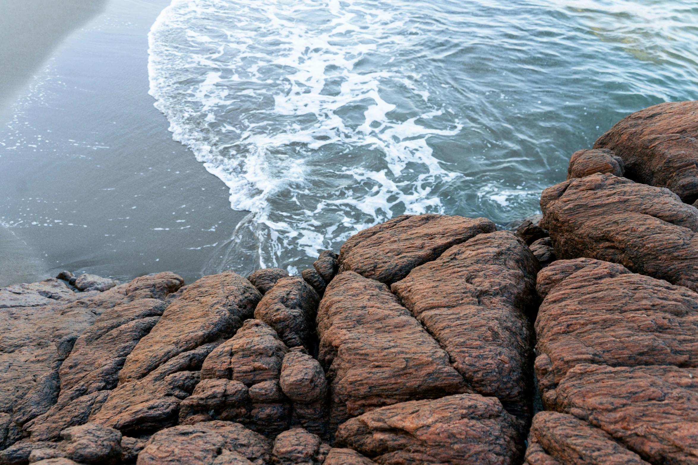 rocks at the edge of water are shown