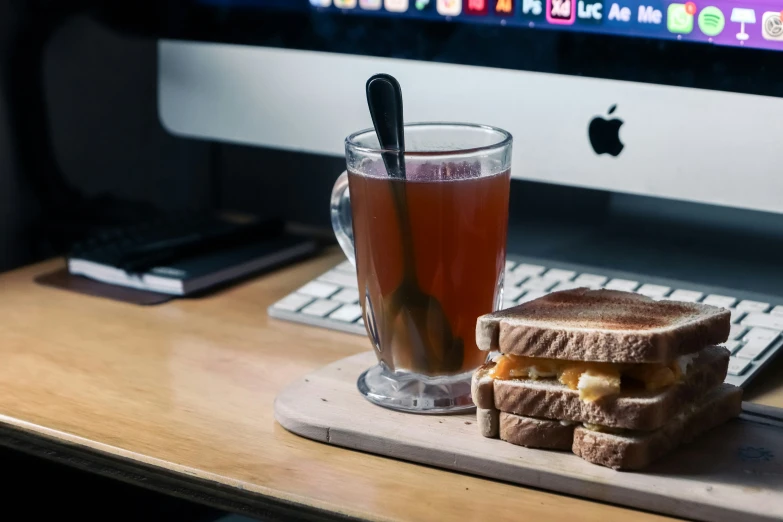 a sandwich and drink sitting on a wooden table