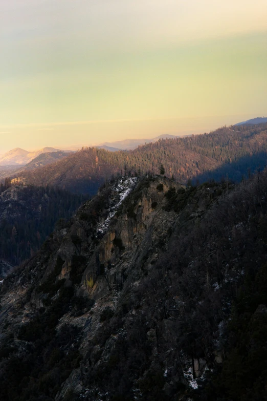 view of mountains with trees and rocks at dusk