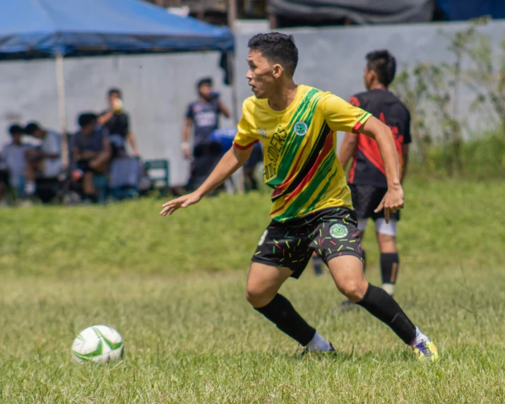 soccer player is looking at ball, while other players watch