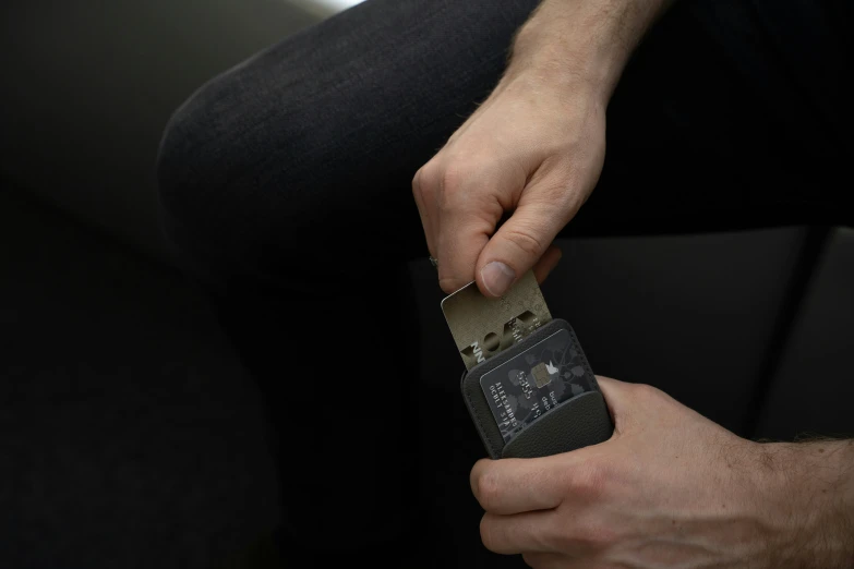 the hand of a man holding a small metal device