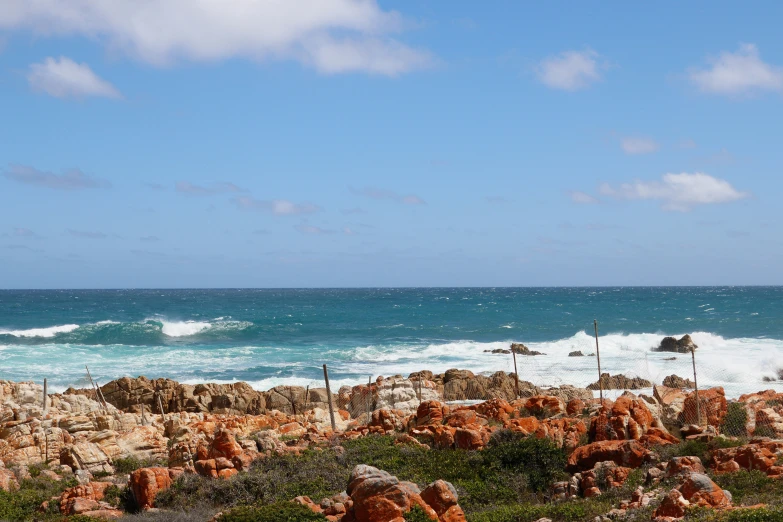 a beach area next to the ocean covered in rocks