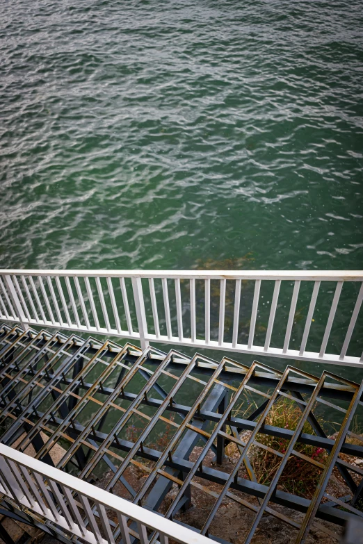 a railing with steps that lead to the water