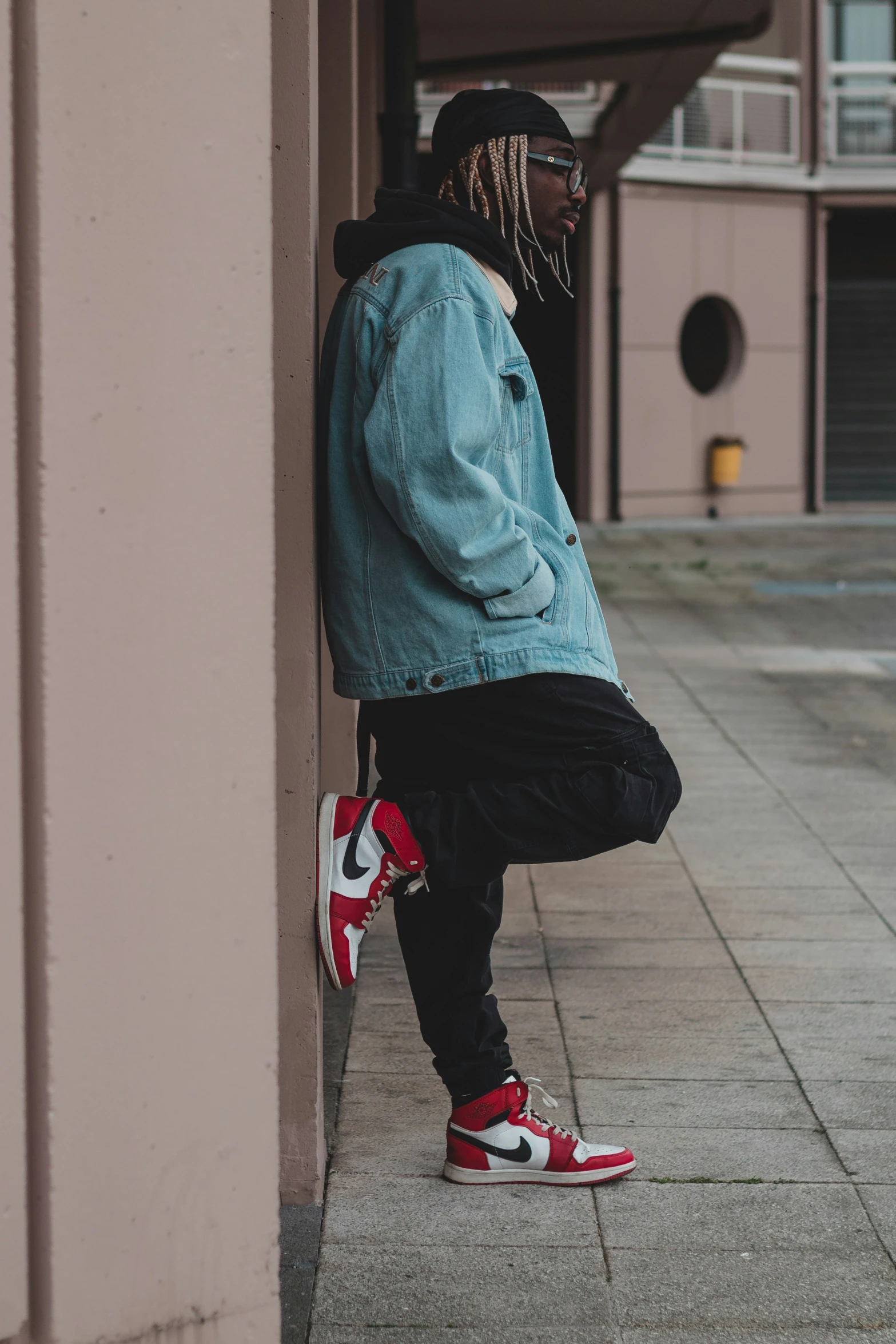 a man sitting on the ledge of a building with his foot propped up