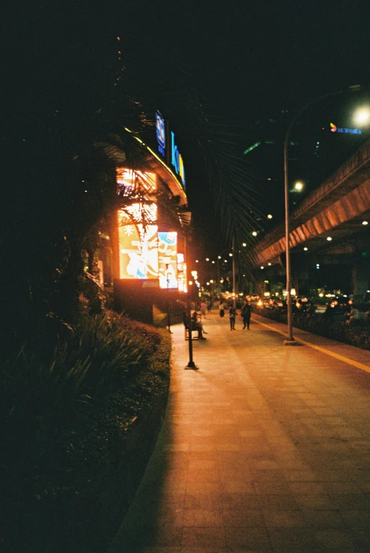 a person walking down a dark street with tall buildings at night