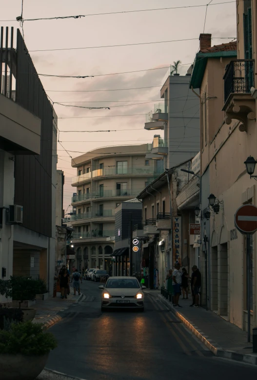 there is a car moving on the road with people walking on it