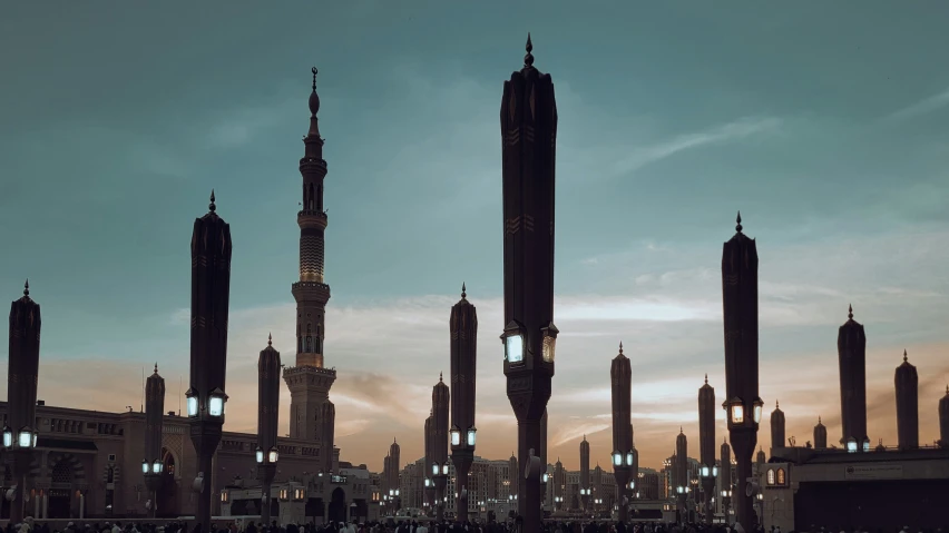 several large spires standing above a city at night