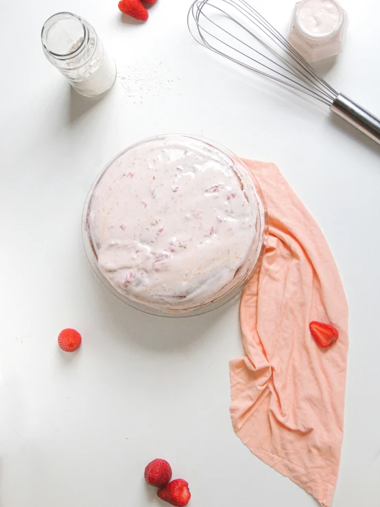 a frosted dessert is on the table next to pink flowers