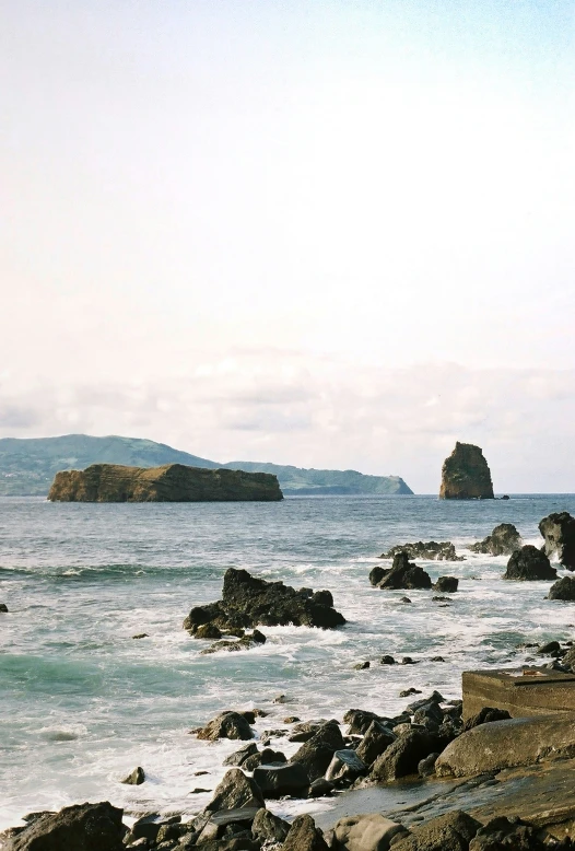 there is some rocks at the water's edge