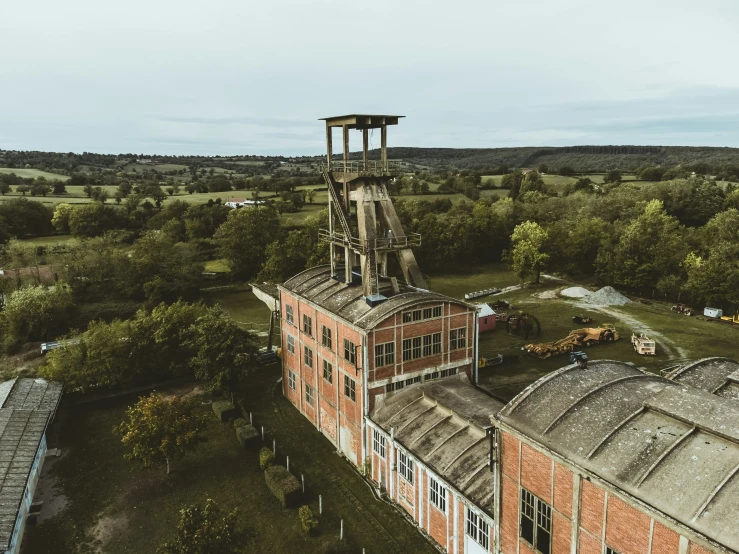 a view from above looking at an old factory and surrounding trees